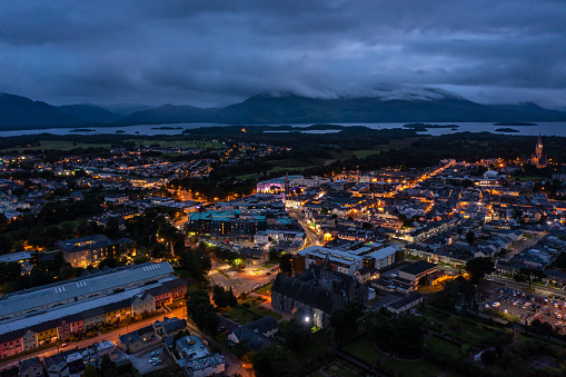 Aerial view of scenic tourist town of Killarney in county Kerry in Ireland with switched on lights under a cloudy early rise morning cloudy sky.