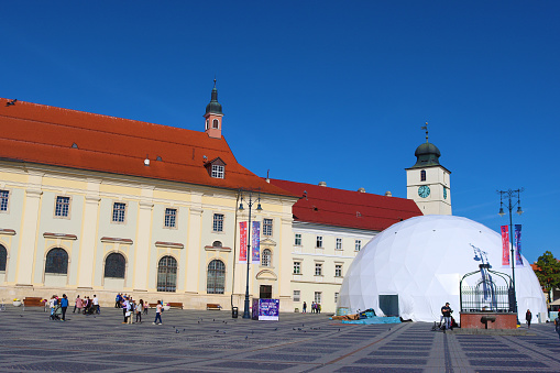 Sibiu, Romania - October 14, 2023: Big square and Council Tower. Unidentified people are walking on the square of the city