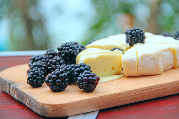 cheese with blueberries on a wooden board. sliced cheese with berries - 18659 stock-fotos und bilder