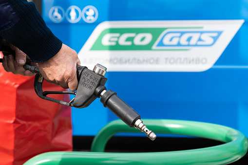 Sochi. Russia - February 14, 2024 Gas refueling pistol. Gas filling. A man hand fills methane gas into a bus.