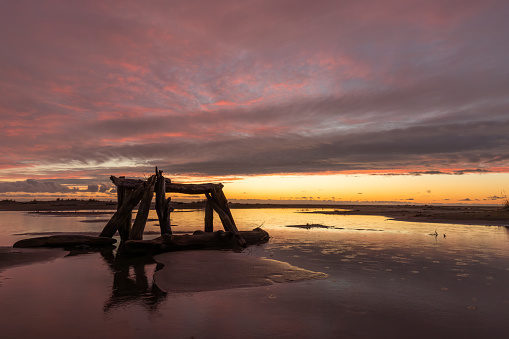 Driftwood structure on the beach at dusk on a rainy day in Westport WA USA