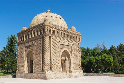 Samani Ismail or Samanid mausoleum in Bukhara. General view in the park with light blue sky at background. Public park, Bukhara (Buxoro), Uzbekistan