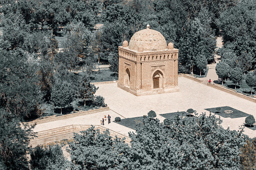 Samani Ismail or Samanid mausoleum in Bukhara. Aerial view in the park, trees at background. Toning. Public park, Bukhara (Buxoro), Uzbekistan
