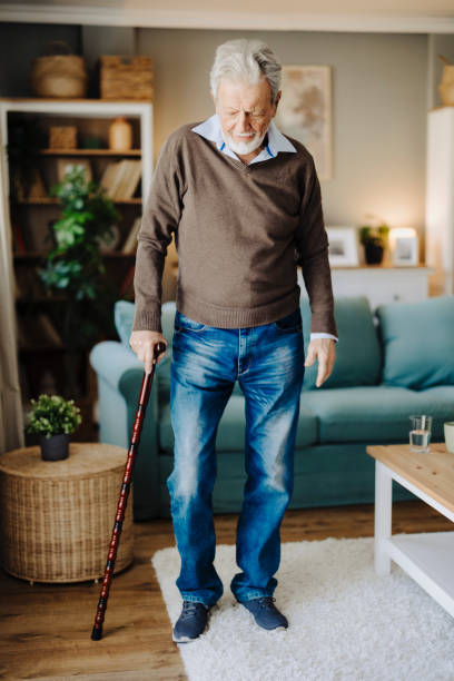 senior man with walking cane at home - human hand aging process senior adult cane ストックフォトと画像