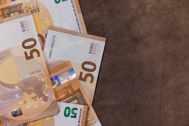istock stack of 50 euro banknotes on brown background With room for text. 2020633640
