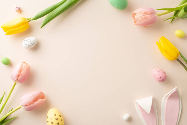 istock Easter Elegance Display: top view colorful eggs, whimsical bunny ears, and fresh tulips arranged on pastel pink. An empty frame invites your text or advert to complete the scene 2020640100