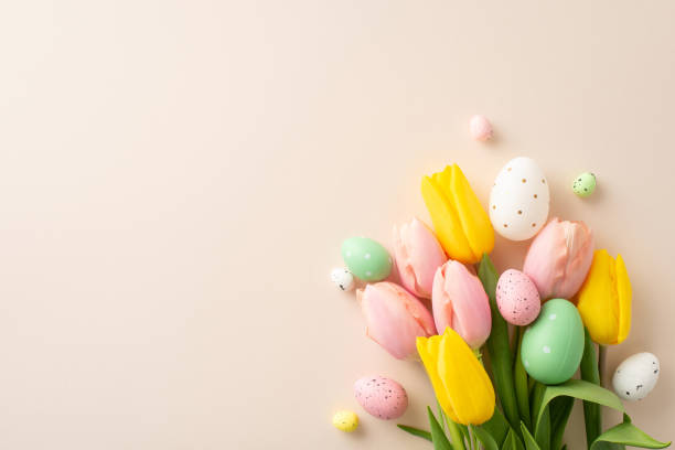 istock Celebrate Easter with this delightful top view image showcasing a charming bouquet adorned with colorful eggs, and fresh tulips. The pastel beige background creates a serene setting for your message 2020640415