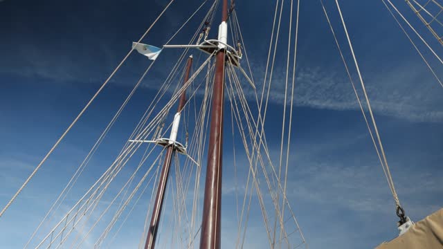 A large vintage wooden yacht sails on the sea. View of the bow of the yacht with furled sails. Pullesy and ropes details Shrouds and ropes close-up of an old sailboat. High quality 4k footage