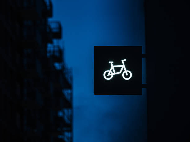 istock Illuminated Bicycle Sign Glowing Against a Twilight Cityscape Background 2020647088