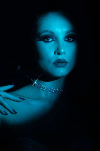 istock Woman portrait partly face covered with shadow and illuminated by blue light 2020652389