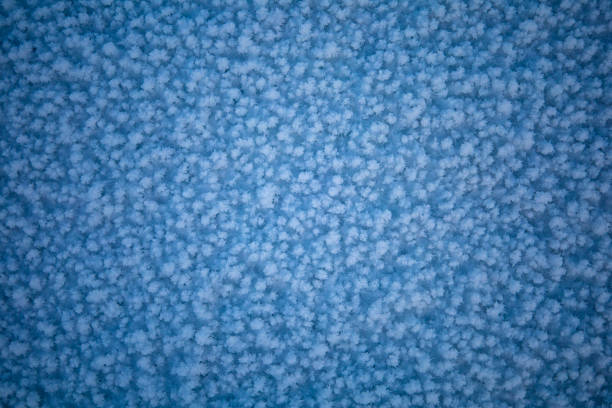 A closeup of a blue woven fabric with an electric blue pattern of white clouds resembling circles, creating a symmetrical and artistic design
