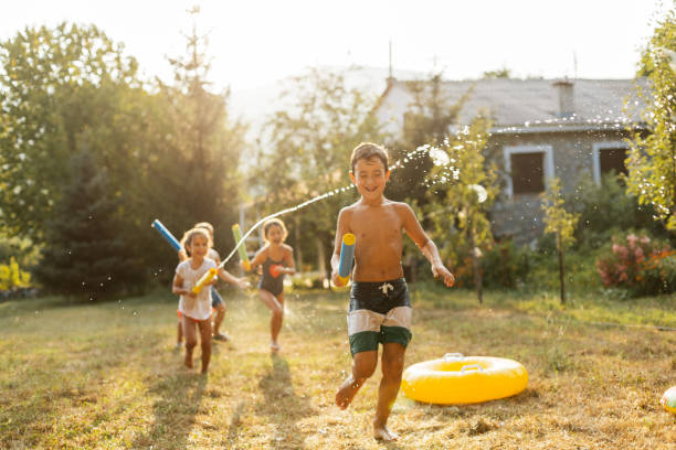Children having a water fight on a hot summer day