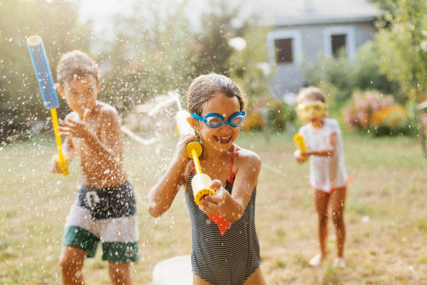Children having a water fight on a hot summer day