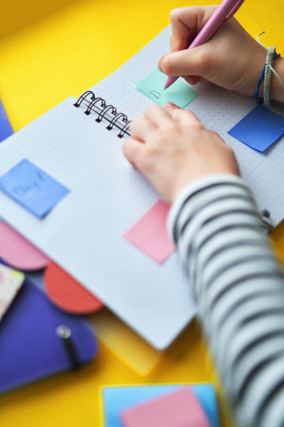 istock Young Girl Writing To-Do-List with Post-Its 2020736516