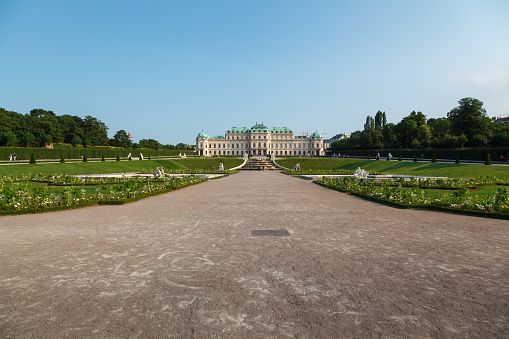 The classical symmetric gardens of the Belvedere palace in Vienna, Austria with its fountain and classic marble sculptures.