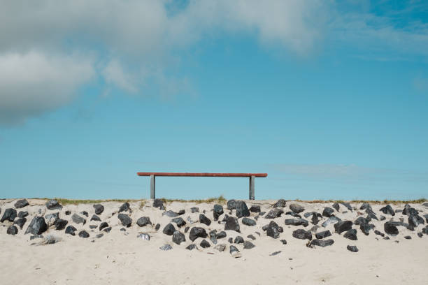 minimalist shot of a bench on the beach
