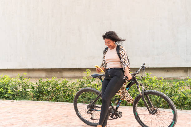 istock Casual Woman Texting on Phone Next to Bicycle 2020751848