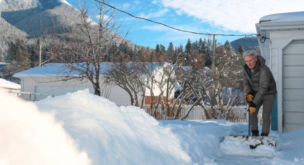 Mature man shovels snow from walkway