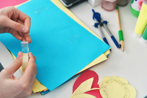 Young Girl Working at her School Project and Using Scoth Tape