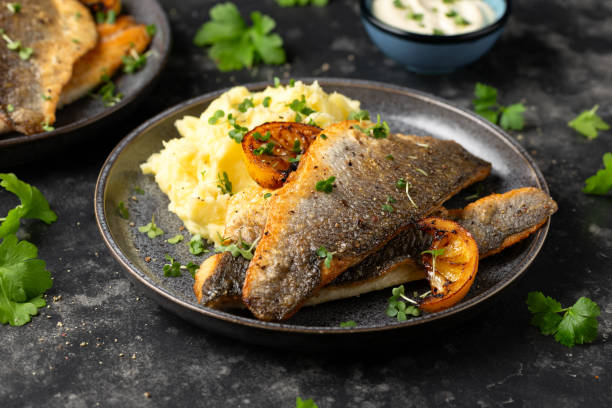 istock Pan fried sea bass fillets served with mashed potatoes and caramelised lemon 2020781915