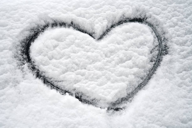 istock close up on drawing hearts on car windshield after snow 2020789469
