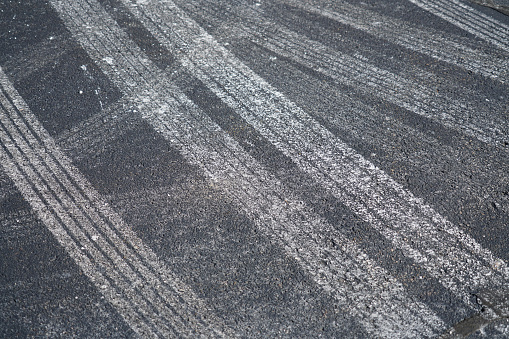 close up on tire tracks with snow melt salt on the street