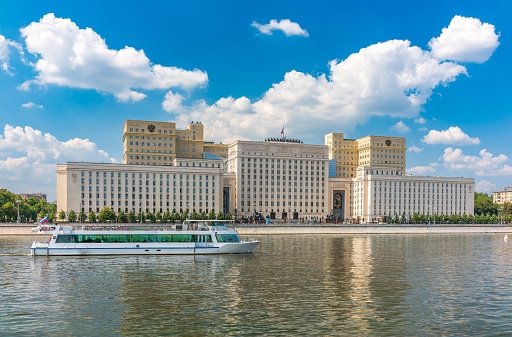 View of the Ministry of Defence of Russian Federation, and Moscow river embakment with cruise ships at sunset. Translation of the inscription on the facade - Ministry of Defense of the Russian Federation