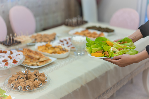 Woman serving traditional Turkish raw meatballs on plate for Iftar dinner. Turkish oriental dishes.