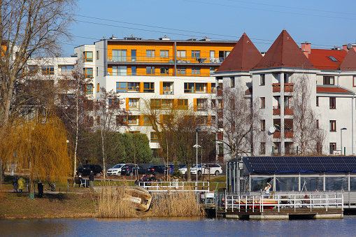 Warsaw, Poland - February 16, 2024: A lakeside cafe in a public park next to blocks of flats in the Goclaw housing estate in the Praga-Poludnie district.