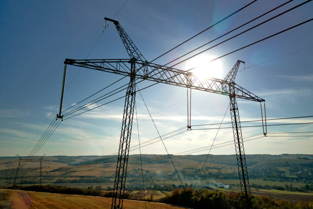 High voltage tower with electric power lines transfening electrical energy through cable wires.