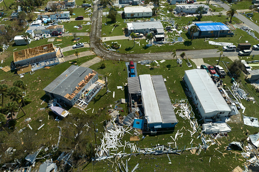 Wind damage of private houses after hurricane swept through Florida mobile home residential area. Consequences of natural disaster.