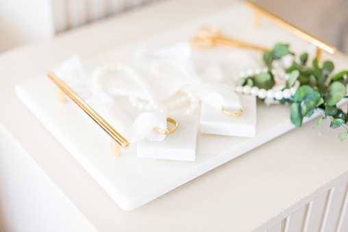 Wedding ring and scissors decorations on a white tray