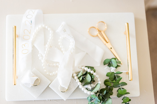 Wedding ring and scissors decorations on a white tray
