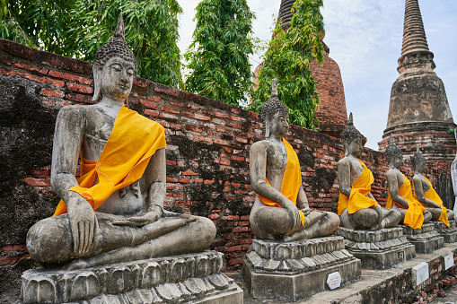 Luang Prabang, Laos - November 22, 2010: Barefoot Buddhist Monks collecting alms in the street from kneeling merit makers