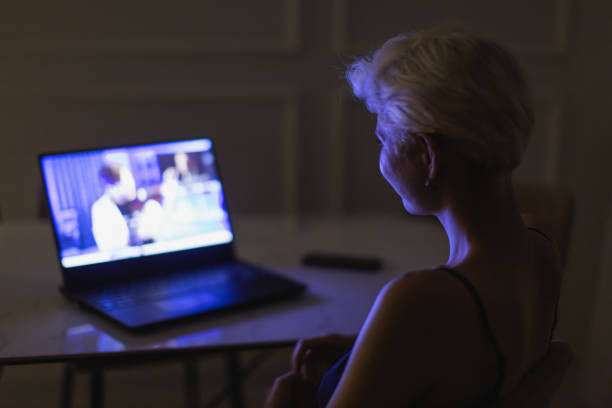 Blonde woman watching video on laptop.