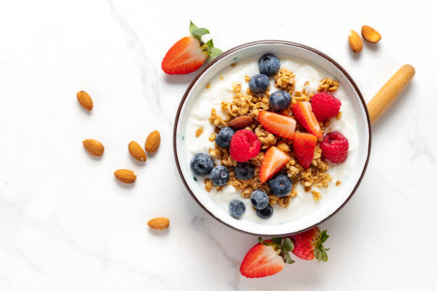 Healthy breakfast bowl top view Weight loss Healthy breakfast bowl with ingredients granola fruits Greek yogurt and berries top view. Weight loss, healthy lifestyle and eating concept yogurt stock pictures, royalty-free photos & images