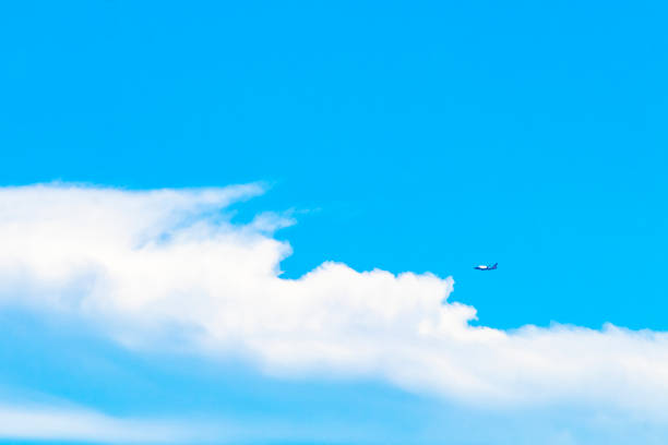 Passenger airplane flies in blue sky with clouds in Playa del Carmen Quintana Roo Mexico.