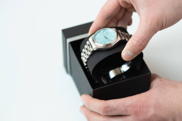 istock close up of man hands picking up taking a wrist watch from a box 2020968951
