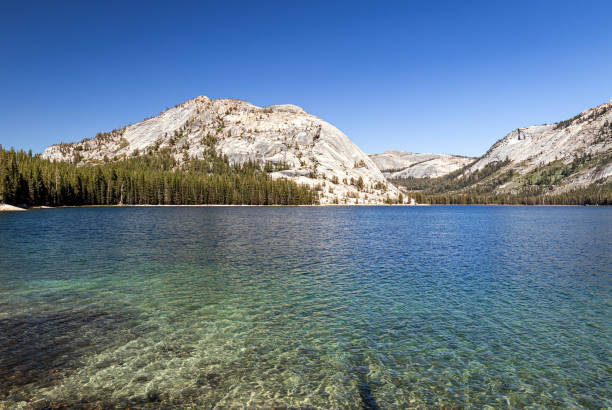 Clear water and mountain landscape with a cloudless clear blue sky in the Sierra Nevada Mountains of Yosemite National Park California, USA.