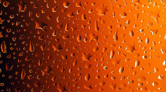 Realistic water drops on abstract orange to black gradient background transparent surface