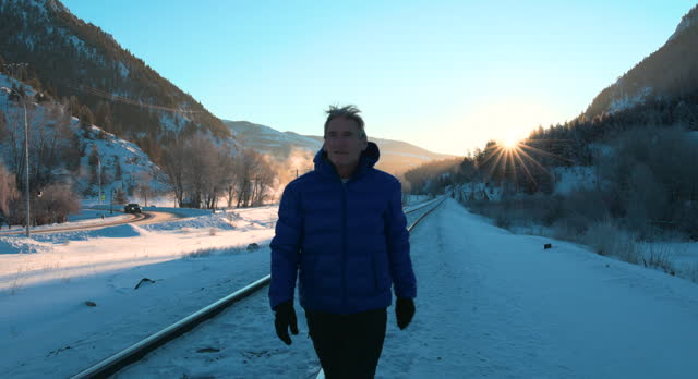 Mature man hikes in snowy winter landscape