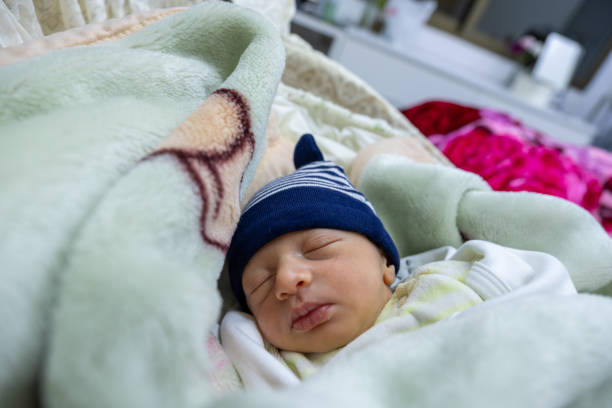 istock sleeping baby wearing cap with fluffy comfy bed 2021093796