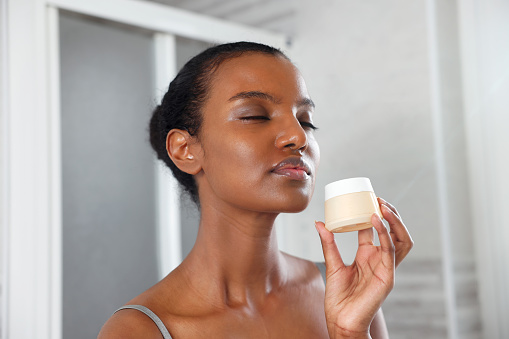Closed Eyes Beautiful Black Woman Holding a Make up Foundation in the Morning, Italy