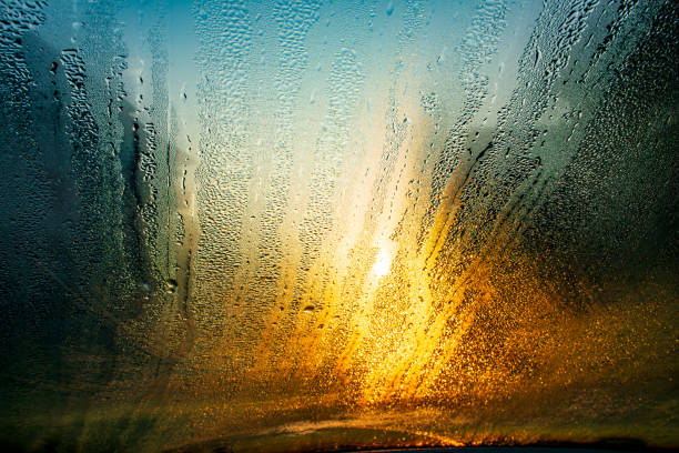 Sunset towards the car windshield in february Condensation on the car windshield in the morning sunset dew stock pictures, royalty-free photos & images