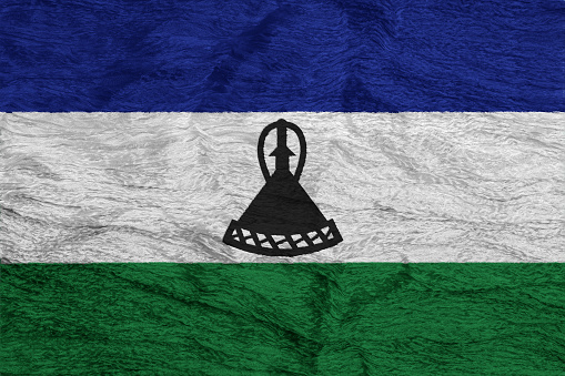 Flag of Kingdom of Lesotho on a textured background. Concept collage.