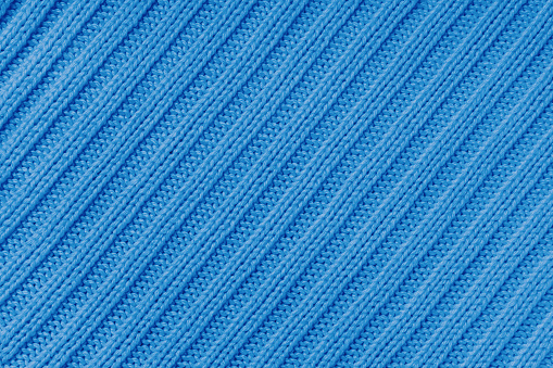 Jersey textile background , blue diagonal striped knitted fabric. Woolen knitwear, sweater, pullover surface texture, textile structure, cloth surface, weaving of knitwear material