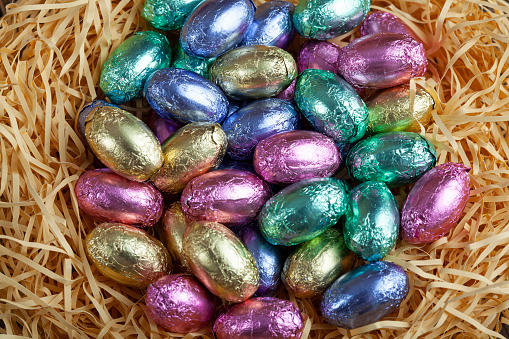 Colorful chocolate Easter eggs in a nest close up