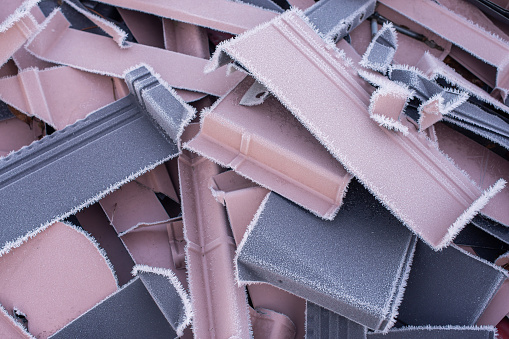 Fragments of roof steel tiles covered in frost.