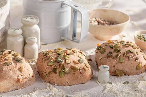 Healthy buns with pumpkin seeds made of flour and sourdough. Rolls baked in a bakery.