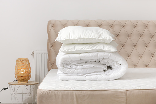 Soft folded duvet and pillows on bed